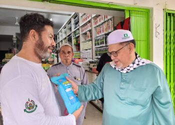 MOHD. Amar Nik Abdullah (kanan) bermesra dengan salah seorang peniaga selepas menyampaikan Kuliah Pagi Jumaat di Dataran Medan Ilmu, Kota Bharu, Kelantan hari ini. -  UTUSAN/MUSTAQIM MOHAMED