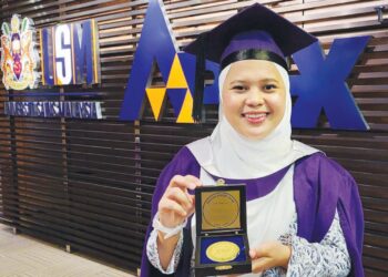 ANDI ARNAISAH Andi Arnis menunjukkan Anugerah Pingat Emas Naib Canselor (Anugerah Bagi Pemimpin Pelajar Cemerlang) yang diterimanya sempena Upacara Konvokesyen USM kali ke-61, di George Town, Pulau Pinang, semalam.