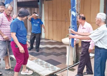 LIM Yee Pang (dua, kanan) bersama rakan-rakannya memasang bendera pada PRK Parlimen Kemaman di bandar Chukai, Kemaman, hari ini. - UTUSAN/NIK NUR IZZATUL HAZWANI NIK ADNAN