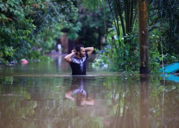 SEORANG penduduk meredah air untuk keluar selepas kawasan rumahnya ditenggelami banjir di Kampung Tersang, Rantau Panjang, Kelantan-UTUSAN/KAMARUL BISMI KAMARUZAMAN
