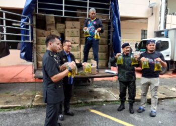 AZMAN Ismail (dua dari kiri) menunjukkan minyak masak yang cuba diseludup ke negara jiran semasa sidang media di Pejabat KPDN Kelantan di Kota Bharu, Kelantan hari ini-UTUSAN/ROHANA MOHD.NAWI.