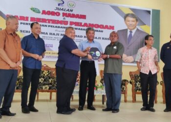 MOHAMAD Hasan (tengah) menyaksikan penyerahan replika kunci traktor kepada PPK Rembau sempena Majlis Perasmian Jualan Agro Madani dan Hari Bertemu Pelanggan PPK Rembau di Dewan Agora Rembau, Rembau hari ini.-UTUSAN/NOR AINNA HAMZAH.