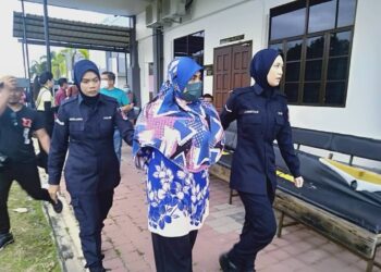 NUR Syuhaidah Mohd. Sani (tengah) dibawa anggota polis selepas berdepan pertuduhan menyebabkan kematian adiknya di Mahkamah Majistret Sungai Petani. -UTUSAN/OTHMAN YAHAYA