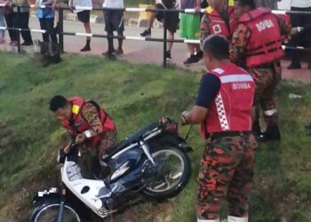 ANGGOTA bomba membantu membawa naik sebuah motosikal yang ditemukan berada di dalam tasik di Taman Tasik Bahau, Jempol pagi tadi.