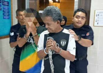MOHAMMED Rashid Rahmat (depan) yang dituduh melakukan amang seksual fizikal terhadap dua kanak-kanak dibawa keluar dari Mahkamah Sesyen Kuala Terengganu, hari ini. - UTUSAN/TENGKU DANISH BAHRI TENGKU YUSOFF