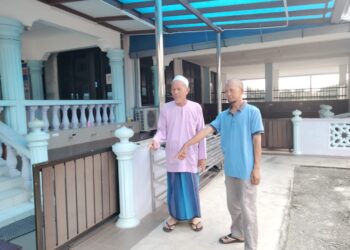 DAUD Salam (kanan) dan Kasiran Saian  menunjukkan kawasan di mana selipar dan kasut digonggong oleh anjing-anjing liar di Mesjid Jamek Parit Haji Siraj, Kayu Ara Pasong Pontian. -UTUSAN/ MUHAMMAD ZIKRI