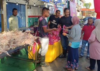 MOHD. SulaImi Hassan (tengah) menyapa salah seorang pelanggan di premisnya di Kampung Wakaf Tembesu, Kuala Nerus, hari ini. - UTUSAN/TENGKU DANISH BAHRI TENGKU YUSOFF