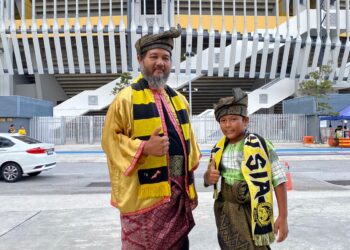 RIMY Azizi bersama anaknya Adam Tuah mengenakan busana tradisional Melayu untuk menyokong Harimau Malaya di Stadium Nasional Bukit Jalil malam ini.