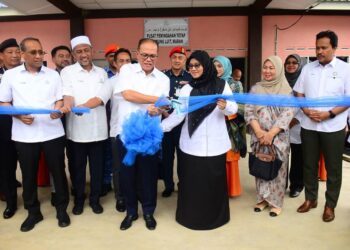 WAN ROSDY Wan Ismail (tengah) menggunting riben sebagai gimik perasmian Pusat Pemindahan Tetap (PPT) yang pertama di Malaysia untuk mangsa banjir di Kampung Luit di Maran, Pahang. - UTUSAN/SHAIKH AHMAD RAZIF