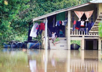 Keadaan sebuah rumah yang dikelilingi air banjir di Kampung Tersang, Rantau Panjang, Kelantan, semalam. - UTUSAN/KAMARUL BISMI KAMARUZAMAN