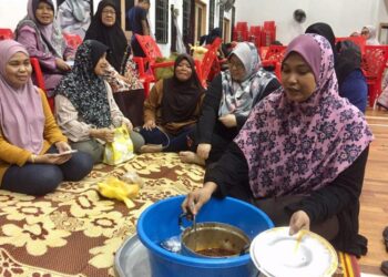 ZARINA Zainuddin (kanan) menyediakan nasi lemak kepada mangsa banjir di PPS Dewan Serbaguna Tok Jembal, Kuala Nerus, hari ini. - UTUSAN/TENGKU DANISH BAHRI TENGKU YUSOFF