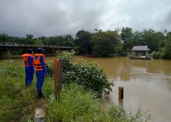 DUA anggota Angkatan Pertahanan Awam (APM) memantau paras air di Sungai Kampung Berangan, Marang, Terengganu, hari ini.  