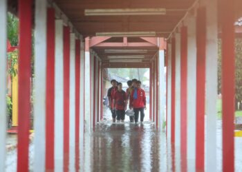 PELAJAR meredah banjir di Sekolah Menengah Kebangsaan Agama Sheikh Abdul Malek, Kuala Terengganu. - UTUSAN/PUQTRA HARRY ROSLI