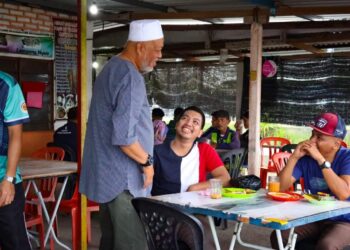 RAJA Mohamed Affandi Raja Mohamed Noor menyantuni pengundi muda ketika kempen PRK Parlimen Kemaman di Kampung Bukit Kuang, Kemaman, hari ini. - UTUSAN/NIK NUR IZZATUL HAZWANI NIK ADNAN