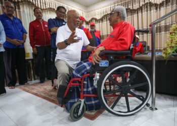 RAJA Mohamed Affandi Raja Mohamed Noor berbual mesra bersama Abu Bakar Ali yang berkerusi roda ketika menziarahinya di Bandar Baharu Kerteh, Kemaman, hari ini. - UTUSAN/PUQTRA HAIRRY ROSLI 