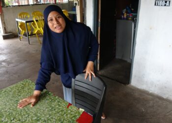 SITI Mariam Md. Noor menceritakan detik cemas disamun dua lelaki yang melarikan begnya di sebuah kedai makan di Kampung Meraga Beris, Kijal, Kemaman, hari ini. - UTUSAN/NIK NUR IZZATUL HAZWANI NIK ADNAN