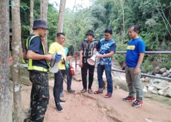 KASWADI Harun (kanan) bersama petugas melakukan demonstrasi penggunaan siren pembesar suara di Lata Kolam Air Deru Ecopark, Besut, Terengganu. - UTUSAN/ WAN ZURATIKAH IFFAH WAN ZULKIFLI