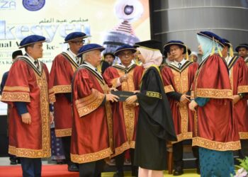 HASLINA Kalang menerima skrol ijazahnya daripada Pro Canselor UniSZA, Tan Sri Yusof Noor dalam majlis konvokesyen universiti itu, Kuala Nerus. - UTUSAN/KAMALIZA KAMARUDDIN