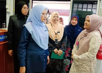 ZALIHA Mustafa (kiri) berbual mesra bersama kakitangan yang bertugas di Klinik Kesihatan Air Putih, Kemaman, hari ini. - UTUSAN/ZAID MOHD. NOOR