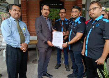 HISHAMUDDIN Hashim menyerahkan memorandum sokongan kepada wakil KDN, Mohamad Khusaini Abdul Manan di Putrajaya. - UTUSAN/AMREE AHMAD