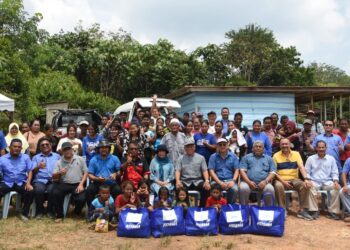 ZAMRI Mohamed (duduk, lima dari kanan) bersama kakitangan Kosma menyantuni masyarakat Orang Asli Kampung Banai, Muadzam Shah di Rompin, Pahang.