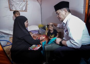 MOHD. Na'im Mokhtar menyantuni sumbangan bantuan kepada mangsa banjir di PPS SMK Dengkil, Selangor. - UTUSAN/FAISOL MUSTAFA