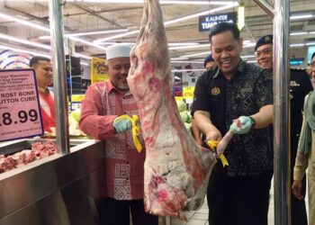 SAHARUDDIN Mohd. Kia (kanan) memotong daging biri-biri import sebagai gimik pelancaran SHMMP Deepavali peringkat negeri di sebuah pasar raya di Kuala Terengganu, hari ini. - UTUSAN/TENGKU DANISH BAHRI TENGKU YUSOFF
