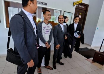 MOHAMMAD Hafizuddin Mohammad (dua dari kiri) kelihatan gembira selepas dibebaskan Mahkamah Tinggi Seremban semalam atas pertuduhan mengedar dadar tiga tahun lalu. - UTUSAN/MOHD. SHAHJEHAN MAAMIN.