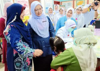 ZALIHA Mustafa (dua dari kiri) beramah mesra bersama seorang ibu yang membawa anaknya menerima rawatan ketika melawat Klinik Kesihatan Air Putih, Kemaman, hari ini. - UTUSAN/ZAID MOHD. NOOR 