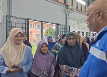 RAJA Mohamed Affandi (kanan) beramah mesra bersama pengundi selepas menyantuni penduduk di Felda Kerteh 5, dekat sini, hari ini. - UTUSAN/NIK NUR IZZATUL HAZWANI NIK ADNAN