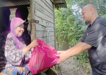 AZIZUL Abdul Rahim menyerahkan bantuan berupa bekalan makanan kepada salah seorang golongan memerlukan di sekitar Pulau Pinang yang dilakukannya sejak 13 tahun lalu. - UTUSAN/SITI NUR MAS ERAH AMRAN