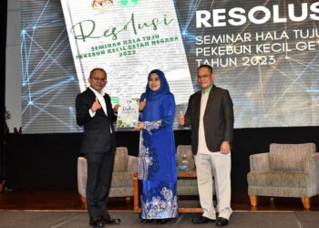 Noraini Ahmad menerima resolusi daripada Abdullah Zainal  pada Seminar Halatuju Pekebun Kecil Getah Negara di Bangi, hari ini.