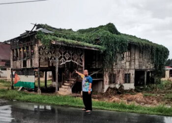 RIDZUAN Mohamad menunjukkan rumah peninggalan ibu bapanya yang usang di Kompleks Sejarah Pasir Salak. - UTUSAN/AIN SAFRE BIDIN
