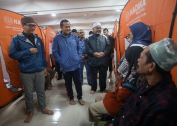 AHMAD Samsuri Mokhtar (dua kiri) beramah mesra dengan mangsa banjir yang berpindah di PPS SK Chendering, Kuala Terengganu, hari ini. - UTUSAN/PUQTRA HAIRRY ROSLI  