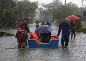 PASUKAN keselamatan membantu memindahkan mangsa banjir di Kampung Tok Jembal, Kuala Nerus, hari ini. - UTUSAN/PUQTRA HAIRRY ROSLI