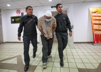 ABDUL  Wahab Idris (tengah) yang mengaku salah mengemukakan borang bantuan banjir mengandungi butir matan palsu dibawa keluar dari Mahkamah Sesyen Kuala Terengganu, hari ini. - UTUSAN/PUQTRA HAIRRY ROSLI