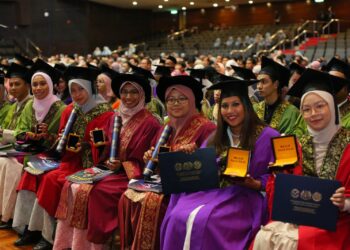 Syarifah Afiqah Syed Shahrin (kanan) dan Brentha Murugan (dua dari kanan) menunjukkan pingat Anugerah Pelajaran Diraja yang diterima pada Konvokesyen Ke-51 Universiti Kebangsaaan Malaysia (UKM) di Bangi, semalam.