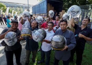 PARA pengunjung menunjukkan topi keledar baharu yang ditukar secara percuma sempena Program Setahun Bersama Kerajaan MADANI di pekarangan Stadium Nasional Bukit Jalil (SNBJ) di sini, hari ini. UTUSAN/FARIZ RUSADIO