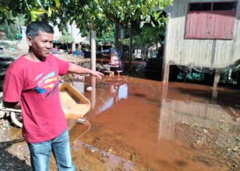 PENDUDUK menunjukkan kawasan rumahnya masih ditenggelami banjir termenung di Kampung Tersang, Rantau Panjang, Kelantan-UTUSAN/ROHANA ISMAIL.