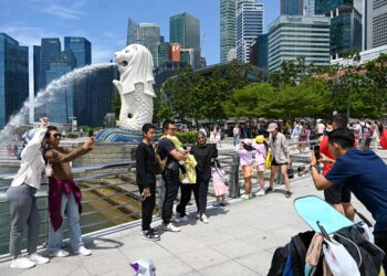 ORANG RAMAI bergambar di mercu tanda Merlion di Marina Bay, Singapura. - AFP