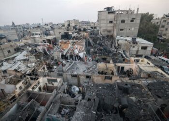 Rakyat Palestin memeriksa kemusnahan di bangunan kediaman akibat pengeboman Israel di Rafah di selatan Gaza.-AFP