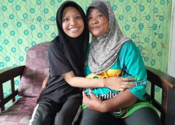 RUZANA Mohamad bersama anak angkatnya, Nurul Ain ditemui di Felda Sening, Kota Tinggi.
