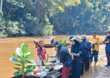 JAMARIZAN Basri (kiri perahu) sedang melayani pengunjung menikmati bufet Perahu Tembeling di Sungai Tahan, Kuala Tahan, Jerantut, Pahang. - UTUSAN/HARIS FADILAH AHMAD