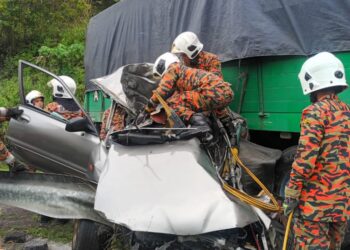 ANGGOTA bomba mengeluarkan mangsa yang tersepit dalam kereta terbabit kemalangan dengan sebuah treler di Kilometer 16.9, Jalan Raya Timur Barat (JRTB) Gerik-Jeli, Gerik hari ini. - UTUSAN/IHSAN JBPM