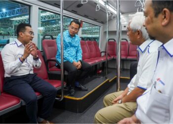 NIK Nazmi Nik Ahmad mendengar penerangan Mohd. Azharuddin Mat Sah (kiri) semasa melawat bas elektirik Prasarana pada Majlis Pelancaran Pelan Tindakan Kelestarian Prasarana di Kompleks BRT Sunway, di sini hari ini. - TUSAN/SHIDDIEQIIN ZON