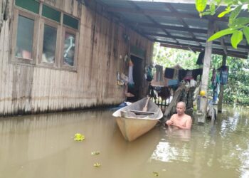 KAMARUDIN Ya perlu berwaspada setiap kali meredah air bagi mengelak digigit lintah selepas kawasan rumahnya ditenggelami air banjir di Kampung Padang Licin, Rantau Panjang, Kelantan. - UTUSAN/ROHANA ISMAIL