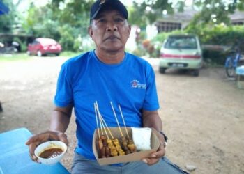 FAIZAL  Rosdi menunjukkan sate ayam dan daging yang laris dijual di Rumah Moyang RR Satay di Kampung Rambah, Pontian, Johor, semalam.