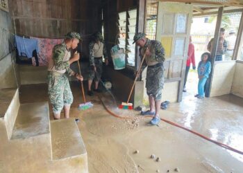 BEBERAPA anggota tentera membantu membersihkan rumah penduduk yang dilanda banjir di Kampung Pasir Raja, Hulu Dungun, Dungun, hari ini. - UTUSAN/NIK NUR IZZATUL HAZWANI NIK ADNAN