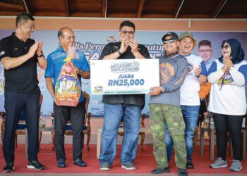 RAZALI Mohd. Taib (kanan) menerima replika cek bernilai RM25,000 disampaikan Ab. Rauf Yusoh (tengah) di Pentas Budaya, Pantai Puteri, Melaka.