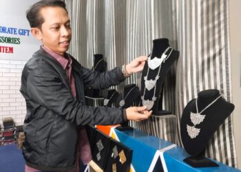 MOHAMAD AZRAI Hussin menunjukkan kraf logam motif bunga kesidang yang dipamerkan di galeri De Legend Craft Enterprise di Durian Tunggal, Melaka. - UTUSAN/MUHAMMAD SHAHIZAM TAZALI
